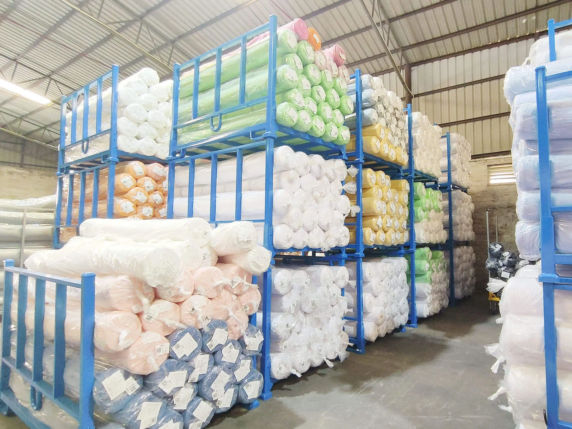 Portable stack racking system storing rolled textile inventory in a warehouse