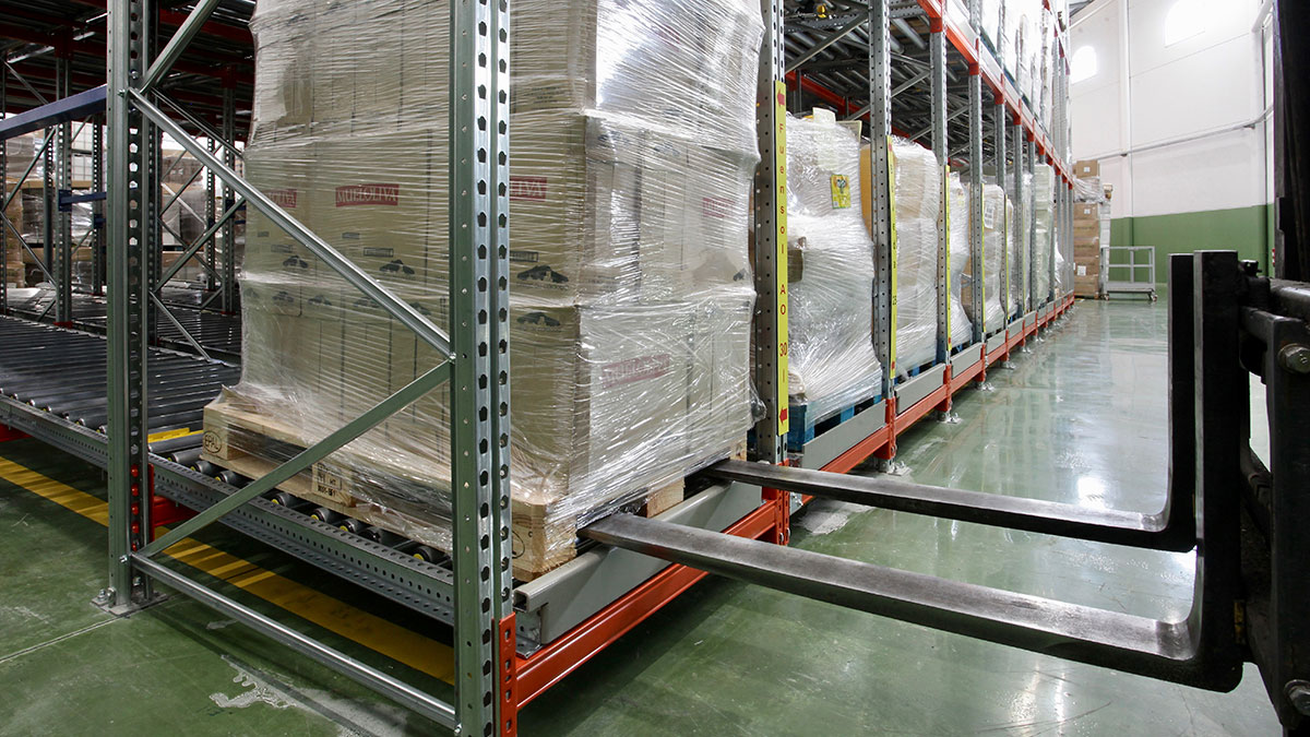 Loaded pallet positioned on high-density push-back racking rails
